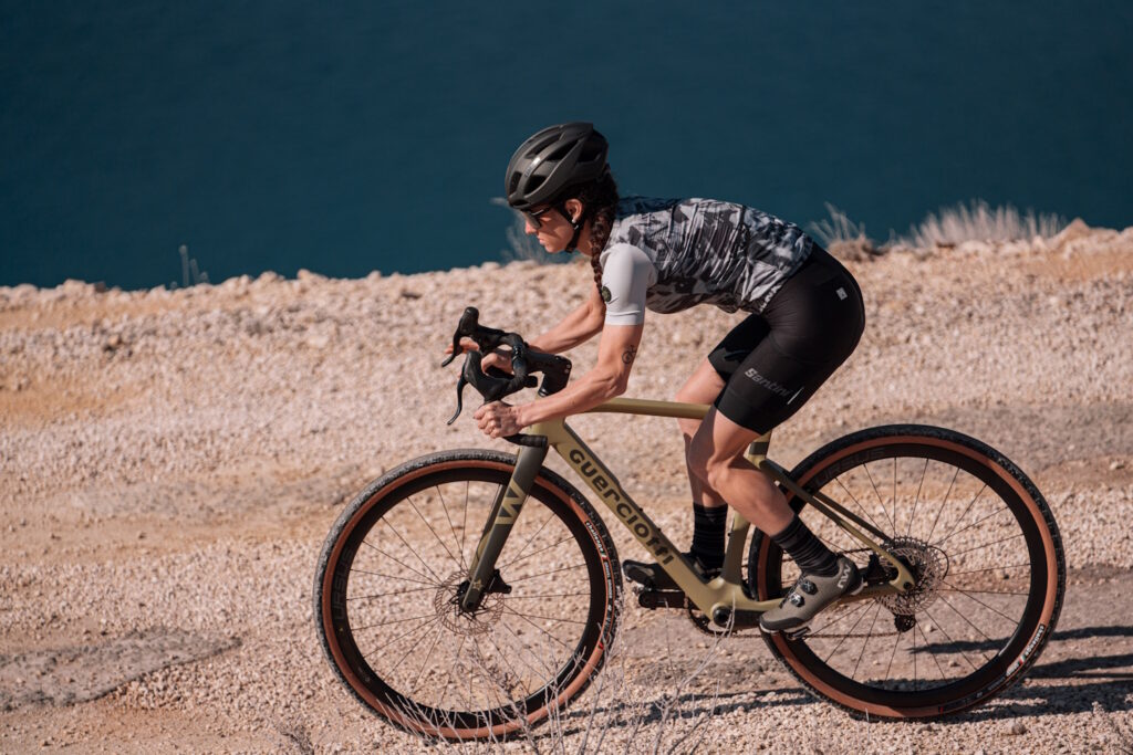 Kvinde på gravelcykel på grus - set fra siden