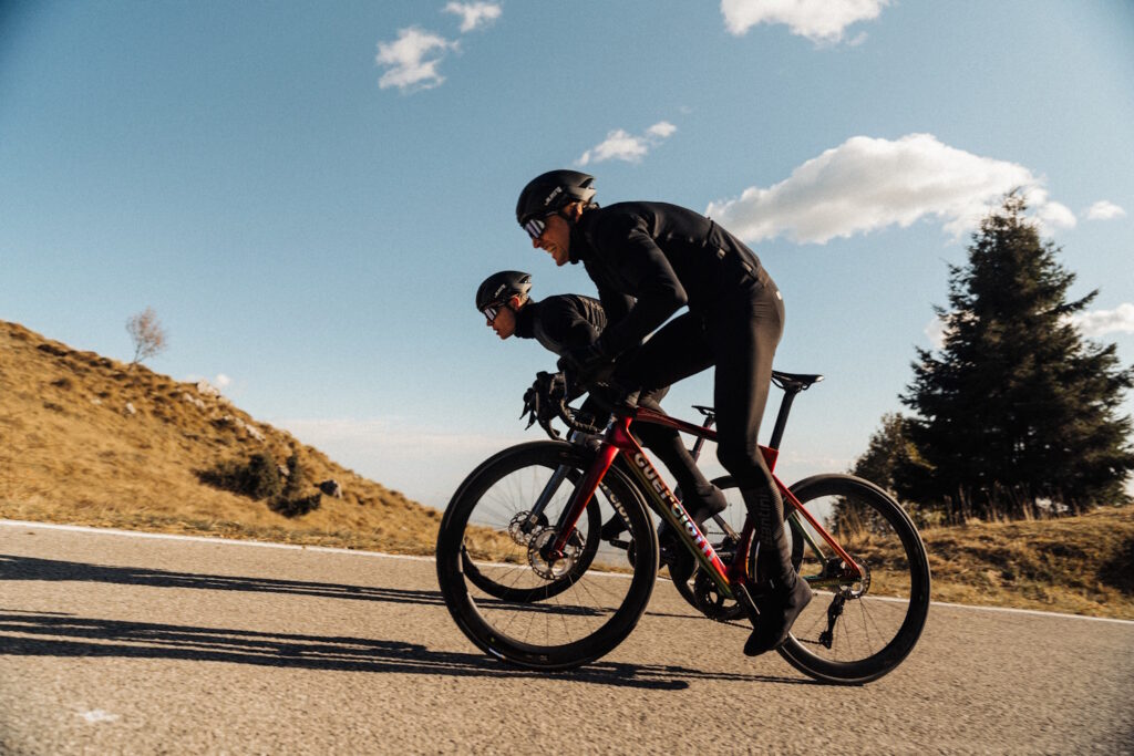 To cyklister på Guerciotti racercykler kører på snoet vej i bjergene